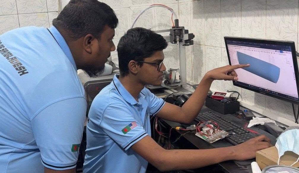 Al Amin Sani explaining a 3D engineering model to a teammate